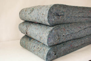 Three folded stacks of the speckled grey Quiet Batt® Soundproofing insulation