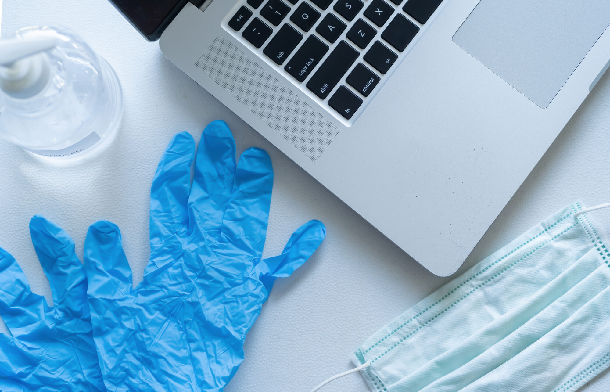 computer with mask, gloves and hand sanitizer