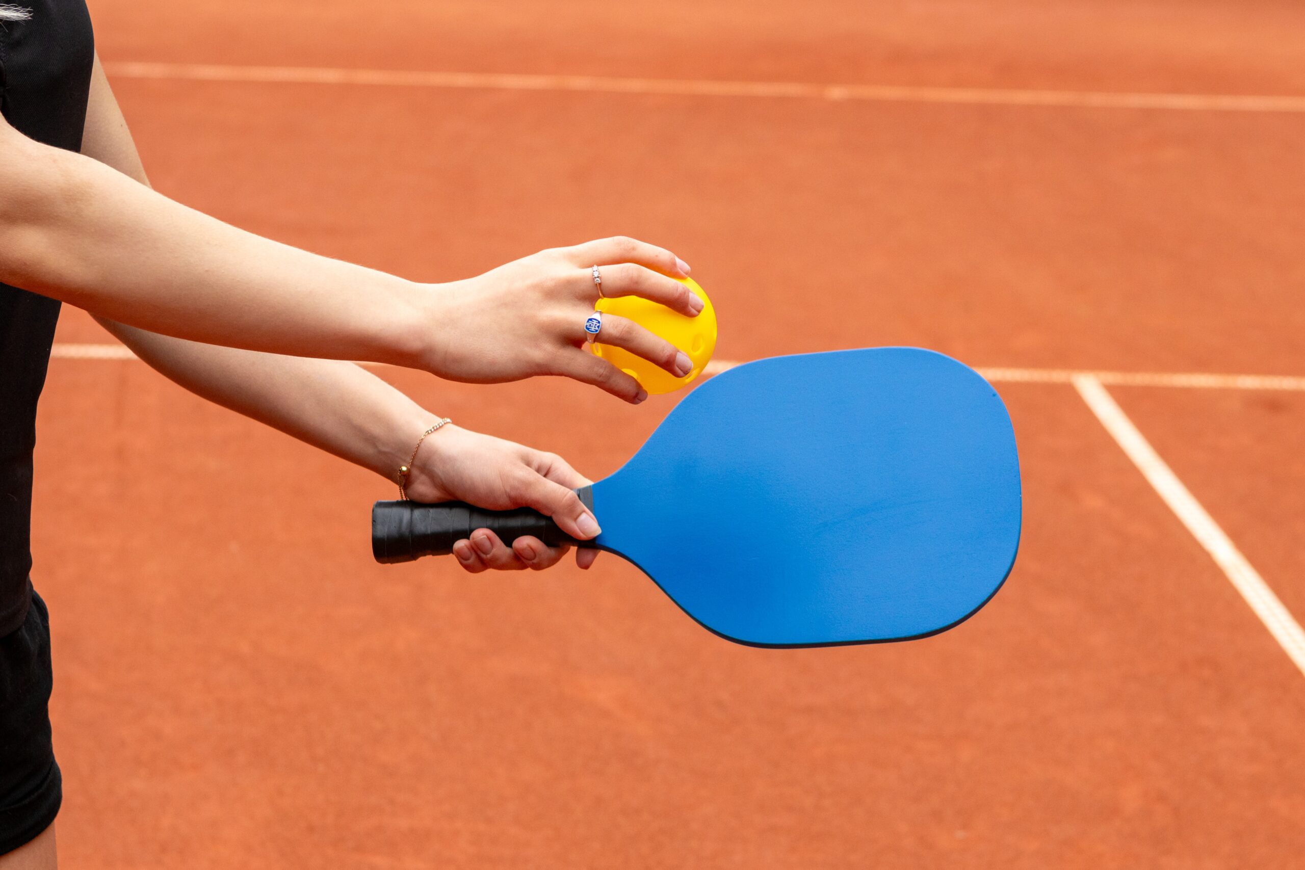 person hitting pickleball with paddle